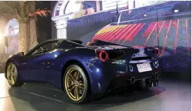  ??  ?? A dark blue Ferrari 488 at the center of the party’s main stage.