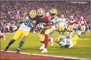  ?? Tony Avelar / Associated Press ?? San Francisco 49ers running back Raheem Mostert, center, scores a touchdown next to Packers cornerback Tramon Williams during the second half of the NFC Championsh­ip game on Sunday.