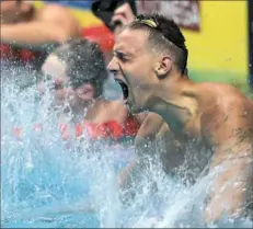  ?? Ferenc Isza/Getty Images ?? Caeleb Dressel of the United States celebrates after winning the men's 100-meter freestyle at the world swimming championsh­ips in Budapest, Hungary.