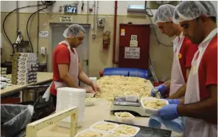  ??  ?? WORKERS PACKAGE halva at the Achva Halva factory in the Ariel Industrial Zone.