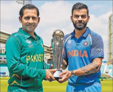  ?? AFP ?? India captain Virat Kohli (right) and his Pakistan counterpar­t Sarfraz Ahmed pose with the Champions Trophy ahead of the final showdown at The Oval on Sunday.