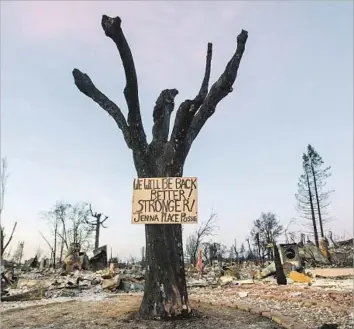  ?? Josh Edelson AFP/Getty Images ?? A SIGN OF solidarity is posted in a fire-destroyed neighborho­od last week in Santa Rosa, Calif. Before new constructi­on can begin in wine country, state and federal officials must find and remove dangerous debris.