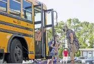  ?? STAFF PHOTO BY C.B. SCHMELTER ?? Assistant Principal Jennifer Rodgers, right, helps students as they get off a bus on the first day of school at Hixson Elementary School on Aug. 12, 2020.