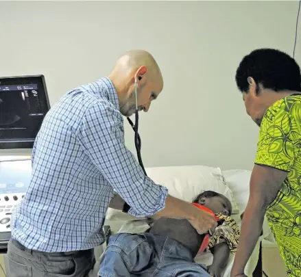  ??  ?? Dr Benjamin Anderson, left, checks one of the 30 congenital heart patients at CWM Hospital today. Dr Anderson is part of the 15-member specialist medical team that will be conducting free surgeries from tomorrow.