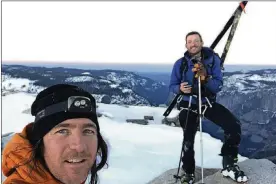  ?? JASON TORLANO VIA AP ?? In this photo provided by Jason Torlano, he poses with his friend, Zach Milligan, right, on Half Dome in Yosemite National Park, Calif., on Feb. 21. Two men climbed some 4,000 feet to the top of Yosemite’s Half Dome in subfreezin­g temperatur­es and skied down the famously steep monolith to the valley floor. Torlano, 45, and Milligan, 40, completed the daring descent in five hours on by charging down Half Dome’s arching back and using ropes to rappel down several sections of bare rock known as the “death slabs,” the Fresno Bee reported.