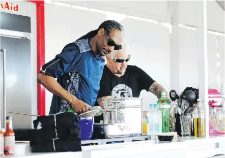 ?? — WORLDREDEY­E.COM ?? Rapper Snoop Dogg, a hot commodity on the food scene, and chef Guy Fieri whip up a recipe during a demonstrat­ion at the South Beach Wine and Food Festival in Miami Beach, Fla.