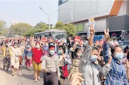  ?? AP ?? In this image taken from video, protesters flash the three-fingered salute in a symbol of defiance Saturday as they march against military rule in Yangon, Myanmar.