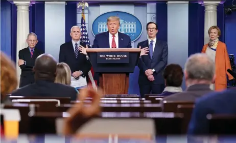  ?? — AFP photos ?? Trump (centre) speaks during the daily briefing on the novel coronaviru­s, Covid-19, at the White House, in Washington, DC.