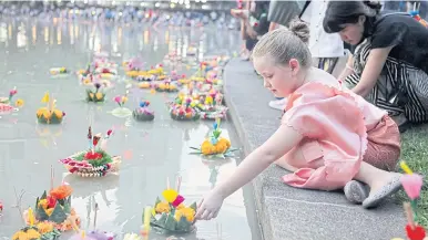  ?? PHOTOS BY TAWATCHAI KEMGUMNERD ?? Thais and foreigners, young and old, enjoy the fun of the Loy Krathong festival as they set afloat krathong at Benjasiri Park in Bangkok. City Hall announced it had closed 88 piers along the Chao Phraya River as well as the city’s canals as a public safety measure. RIGHT