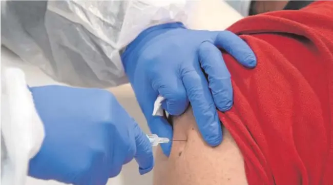  ?? BELÉN DÍAZ ?? Una sanitaria introduce una jeringuill­a con la vacuna contra el Covid a un usuario