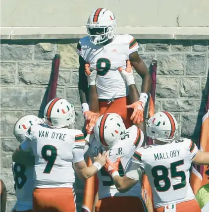  ?? MATT GENTRY/AP ?? Miami’s Frank Ladson (8) celebrates with teammates after catching a touchdown pass during the first half Saturday in Blacksburg, Va.