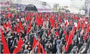  ?? (AFP) ?? Mourners raise portraits of Mohsen Hojaji during a funerary procession for him in Tehran on Wednesday