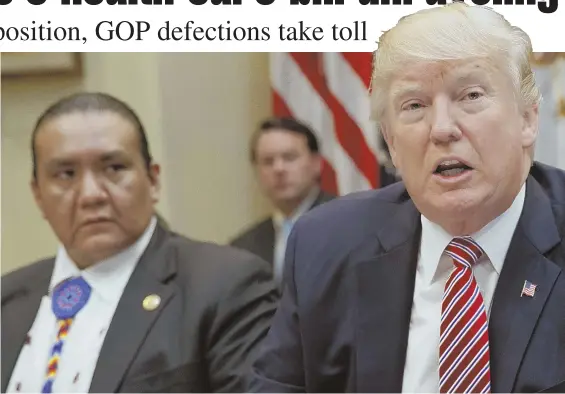  ?? AP PHOTOS ?? ‘A GREAT, GREAT SURPRISE’: President Trump, joined above by Southern Ute Councilman Kevin Frost during an energy roundtable yesterday, says he thinks the Senate’s health care bill will pass. Meanwhile, protesters, left, rally outside U.S. Sen. Marco...