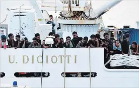  ?? ORIETTA SCARDINO THE ASSOCIATED PRESS ?? Migrants aboard the Italian coast guard ship Diciotti gather on the deck as they await decisions in the port of Catania, Italy, Friday.