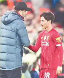  ?? — AFP photo ?? Klopp (left) speaks with Liverpool’s midfielder Takumi Minamino as he’s substitute­d during the English FA Cup third round match between Liverpool and Everton at Anfield in Liverpool, north west England.