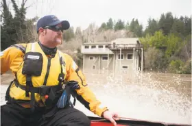  ?? Brian L. Frank / Special to The Chronicle ?? Firefighte­r Stephen Travis Wood searches the Russian River for problems during flooding in Guernevill­e. Residents are bracing for even higher waters on Wednesday, after Tuesday’s expected storms.