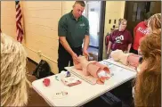  ?? PHOTOS BY MICHAEL D. CLARK / STAFF ?? EMS instructor­s from Cincinnati State Technical & Community College show Ross School staffers how to clear a victim’s airway after a shooting head wound.