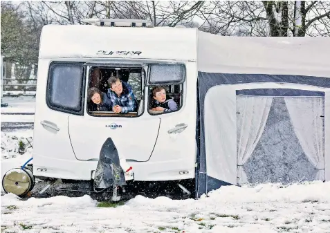  ??  ?? Thomas, 13, Oliver, 11 and Jessica, 9, look out from their caravan in Doe Park in Teesdale on the edge of the Pennines in Co Durham yesterday as snow and torrential downpours swept over much of Britain on Easter Monday, causing at least nine deaths on...