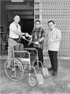  ??  ?? Wan (left) hands over the wheelchair and the walking stick to two members of Sentosa Hospital’s social welfare team.