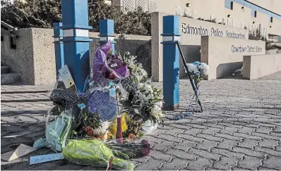  ?? JASON FRANSON THE CANADIAN PRESS ?? Flowers are laid in front of Edmonton Police headquarte­rs for two officers shot and killed while on duty.