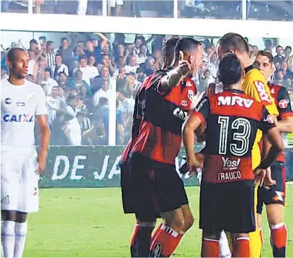  ??  ?? O árbitro Leandro Vuaden é cercado por jogadores rubro-negros após assinalar o pênalti para o Santos