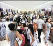  ?? PICTURES: MOTSHWARI MOFOKENG ?? Gem Schoolwear owner Ahmed Pandor helps Isabella Kannah try on her tracksuit, while mom Dimple looks on. RIGHT: The shop was packed to capacity as parents flocked to purchase new uniforms.