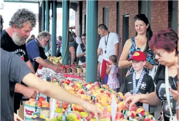  ?? PHOTOS BY BERND FRANKE/TRIBUNE STAFF ?? Fresh locally produced fruits and vegetables tops the shopping list for Welland Farmers' Market regulars.