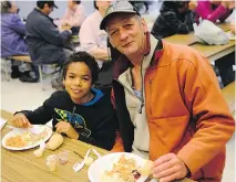  ?? JAMES PARK ?? Roger and son Tyrell Hooper enjoy Thanksgivi­ng dinner served by student volunteers Sunday at Sir Guy Carleton Secondary School.