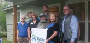  ?? Staff photo by Greg Bischof ?? ■ Nash, Texas, resident David McGrew holds a Habitat For Humanity sign with Habitat Director Mary Wormington to his right. McGrew is a 72-year-old Army Vietnam veteran who wanted to live closer to his church. His new home, now in the 100 block of Weymeadow Drive in Nash, also places him closer to grocery stores.