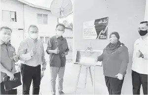  ??  ?? KEMUDAHAN: Abdul Karim (tengah) melancarka­n WiFi Saluran di Kampung Sambir, Asajaya. Turut kelihatan Zaidi (kanan) dan Rubiah (dua kanan).