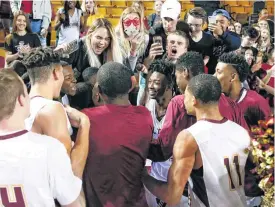  ??  ?? Putnam City North players celebrate with fans after beating Norman North 73-64 in a Class 6A state semifinal Friday at Mabee Center in Tulsa.