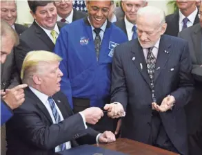  ?? POOL PHOTO BY OLIVIER DOULIERY ?? President Donald Trump presents a pen to astronaut Buzz Aldrin after signing an order to re-establish the National Space Council on June 30, 2017. On Monday, Trump called for “American dominance in space.”