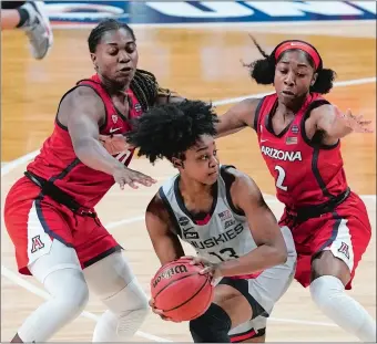  ?? MORRY GASH/AP PHOTO ?? UConn guard Christyn Williams, center, looks to pass around the defense of Arizona’s Trinity Baptiste, left, and Aari McDonald during Friday night’s NCAA Final Four semifinal at the Alamodome in San Antonio. The Wildcats beat a defensive vise on the Huskies and advance to today’s final with a 69-59 victory.