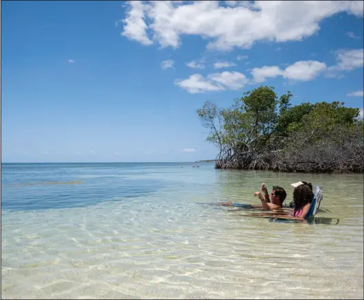  ?? ?? People enjoy the beach in Guanica, Puerto Rico on March 28, 2024.
Photo by Ricardo Arduengo for The Washington Post