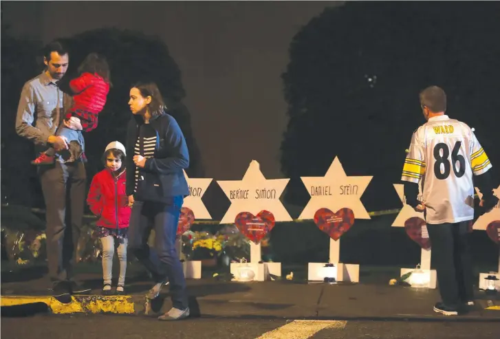  ?? (Reuters) ?? MOURNERS IN Pittsburgh remember the fallen.