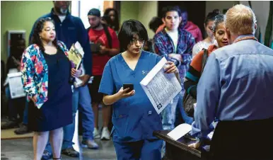  ?? Brett Coomer / Houston Chronicle ?? Taxpayers line up Monday to receive assistance filing their returns at the Baker Ripley Tax Center. Service providers including H&R Block and Liberty Tax reported full waiting rooms.