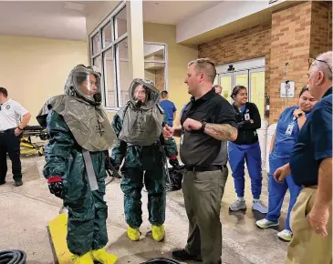  ?? Greenwich Hospital/Contribute­d photo ?? Greenwich Hospital Emergency Department personnel wearing protective gear listen to instructio­ns from a member of Yale New Haven Health Office of Emergency Preparedne­ss during a recent decontamin­ation drill.