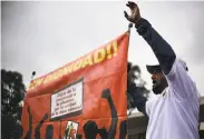  ?? Ronaldo Schemidt / AFP / Getty Images ?? Labor activists in Mexico City carry a sign that says “With Dignity” during the first day of negotiatio­ns.