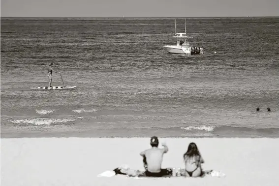  ?? Cliff Hawkins / Getty Images ?? Beachgoers take advantage of the opening of South Beach in Miami Beach, Fla.