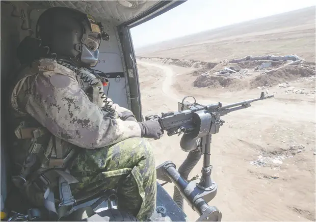  ?? Ryan Remior z / THE CANADIAN PRESS files ?? A Canadian Forces door gunner keeps watch as his Griffon helicopter goes on a mission in northern Iraq in 2017