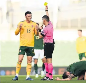  ??  ?? Wales striker Kieffer Moore is shown a yellow card by Anastasios Sidiropoul­os