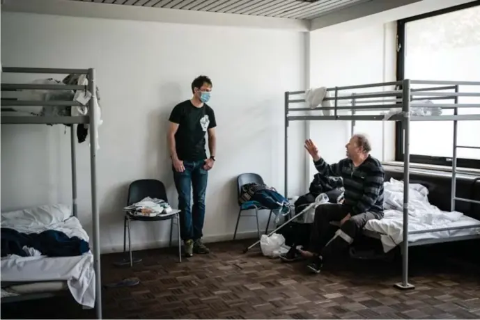  ??  ?? Sébastien Roy (links) maakt een praatje met een dakloze in het opvangcent­rum Poincaré. ‘Vorig jaar hebben we dit centrum moeten evacueren vanwege bedwantsen.’