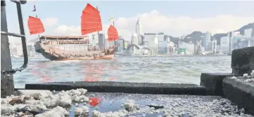  ??  ?? Congealed palm oil washes up on the shoreline at Victoria Harbour in Hong Kong. — AFP photo