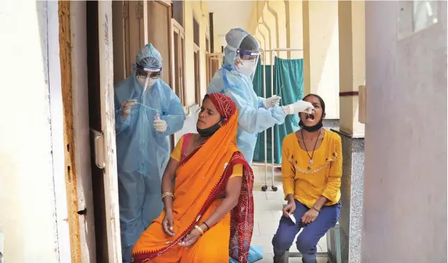  ?? Associated Press ?? ↑
Health workers collect swab samples from residents to test for COVID-19 in New Delhi on Friday.