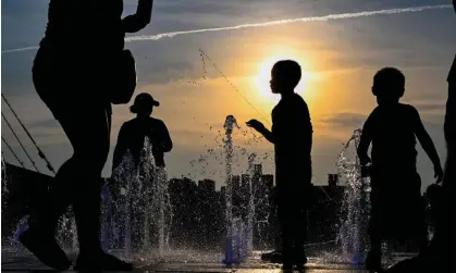  ?? ?? Children cool off in a fountain in Domino Park, Brooklyn with the Manhattan skyline in the background. Photograph: Alexi Rosenfeld/ Getty Images