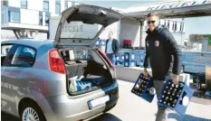  ?? Foto: Ulrich Wagner ?? Andreas Luthe packt mit an: Der Torhüter des FC Augsburg trägt zwei Bierkästen zu einem Auto.