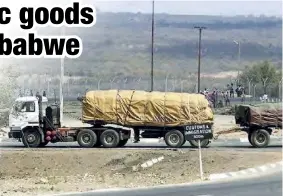  ??  ?? A truck and trailer loaded with 30 tonnes of maize drives into a Beitbridge customs and immigratio­n control point on the South African border with Zimbabwe.