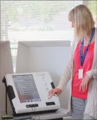  ?? NEWS PHOTO GILLIAN SLADE ?? City clerk Angela Cruickshan­k, returning officer in the upcoming municipal election, demonstrat­es the Express Vote machines available to anyone at advance polls to address the specific requiremen­ts of those with a disability.