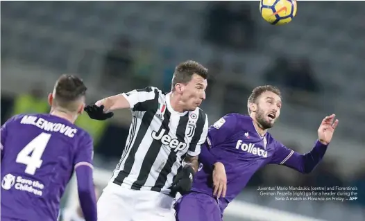  ?? — AFP ?? Juventus’ Mario Mandzukic (centre) and Fiorentina’s German Pezzella (right) go for a header during the Serie A match in Florence on Friday.