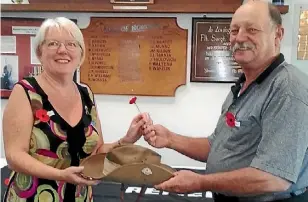  ?? SUPPLIED ?? Wellsford Hospice Shop manager Gaye Ward handing over an Australian diggers hat to Wellsford RSA president Terry Blakemore